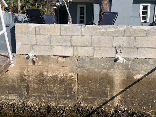 Cracked block seawall with tie-back anchors and corrosion staining